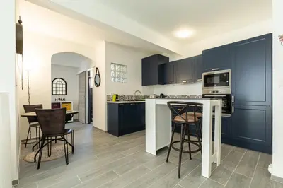 a kitchen with blue cabinets and a table and chairs at IMMOGROOM - Renovated - Terrace - Air conditioning - Quiet - Carnot in Cannes