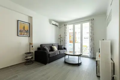 a living room with a couch and a table at IMMOGROOM - Renovated - Terrace - Air conditioning - Quiet - Carnot in Cannes