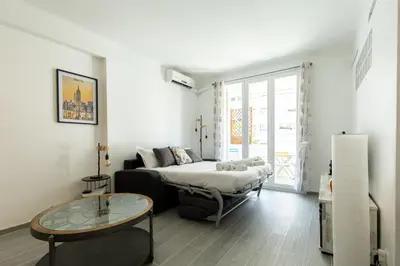 a living room with a bed and a coffee table at IMMOGROOM - Renovated - Terrace - Air conditioning - Quiet - Carnot in Cannes