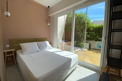 a bedroom with a bed and a large window at Secret Garden ideal for Congrès and Holidays LIVE IN LE FLORENCE in Cannes