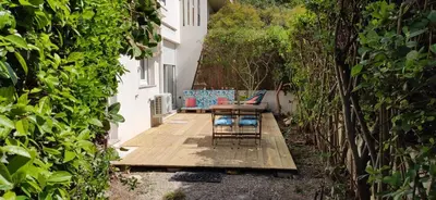 a patio with chairs and a table on a wooden deck at Secret Garden ideal for Congrès and Holidays LIVE IN LE FLORENCE in Cannes