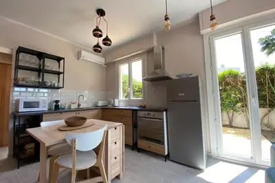 a kitchen with a table and a refrigerator at Secret Garden ideal for Congrès and Holidays LIVE IN LE FLORENCE in Cannes
