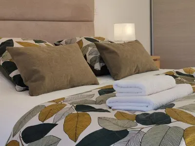 a bed with towels and pillows on it at CHESTER Riviera Escape - Appartement calme, terrasse & clim proche Croisette et centre in Cannes