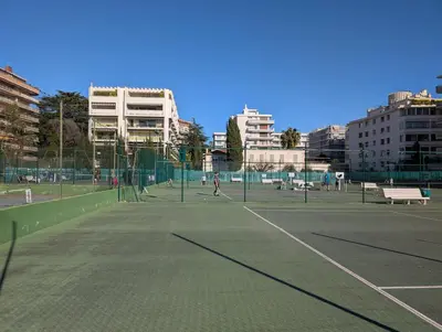 a tennis court with people playing tennis on it at CHESTER Riviera Escape - Appartement calme, terrasse & clim proche Croisette et centre in Cannes