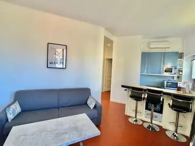 a living room with a couch and a kitchen at Cannes Suquet by Welcome to Cannes in Cannes