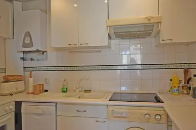 a kitchen with white cabinets and a sink at Palais Alexandre III in Cannes