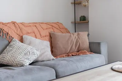 a couch with pillows on it in a living room at Cosy Studio, Cannes centre in Cannes