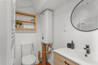 a white bathroom with a toilet and a mirror at Cosy Studio, Cannes centre in Cannes
