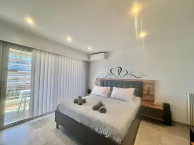 a bedroom with a large bed and a balcony at Maryline by Welcome to Cannes in Cannes