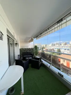 a living room with a table and a large window at Maryline by Welcome to Cannes in Cannes