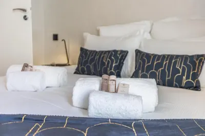 a white bed with towels and pillows on it at Résidence Topaze - Central - Luxurious - 50m Croisette Palais - LRA CANNES in Cannes