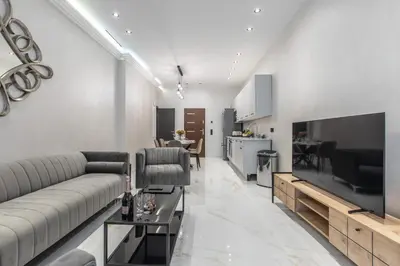 a living room with a couch and a flat screen tv at Résidence Topaze - Central - Luxurious - 50m Croisette Palais - LRA CANNES in Cannes