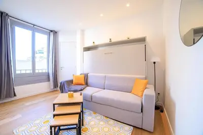 a living room with a couch and a large window at L'Elégance Hoche - Congrès Palais - Plage Croisette - Cannes Centre - Clim in Cannes