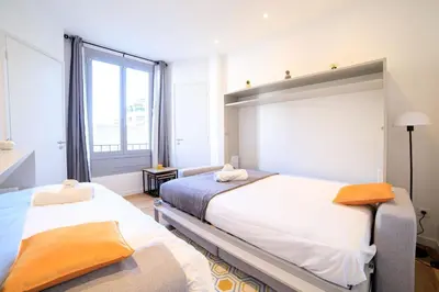 a bedroom with two beds and a large window at L'Elégance Hoche - Congrès Palais - Plage Croisette - Cannes Centre - Clim in Cannes