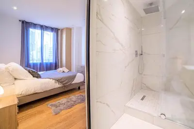 a bathroom with a shower and a bed in a room at L'Elégance Hoche - Congrès Palais - Plage Croisette - Cannes Centre - Clim in Cannes