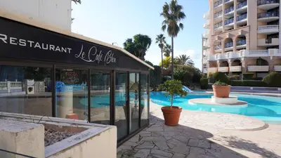 a hotel with a swimming pool and a building at Appartement 607, vue mer, 4 personnes By Palmazur Vacances in Cannes