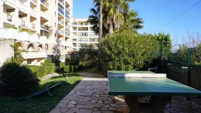 a green bench in front of a building at Appartement 607, vue mer, 4 personnes By Palmazur Vacances in Cannes