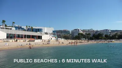 a beach with people in the water and buildings at Super Central Cannes - all comfort - Calm in Cannes