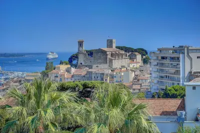 a city with a castle on a hill with palm trees at Super Central Cannes - all comfort - Calm in Cannes