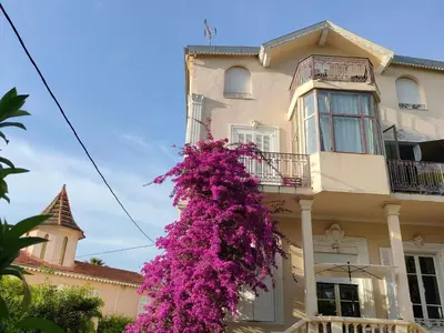 a building with a bunch of purple flowers on it at 3 rooms, 2 bathrooms, in a villa. Lightfull, quiet and charm in Cannes