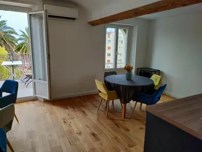 a dining room with a black table and yellow chairs at 3 rooms, 2 bathrooms, in a villa. Lightfull, quiet and charm in Cannes