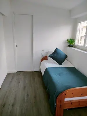 a small bedroom with a bed and a window at 3 rooms, 2 bathrooms, in a villa. Lightfull, quiet and charm in Cannes