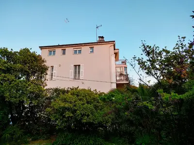 a pink building on a hill with trees at 3 rooms, 2 bathrooms, in a villa. Lightfull, quiet and charm in Cannes