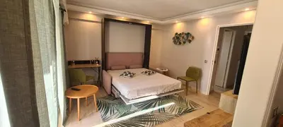 a small bedroom with a bed and a table at Luxury studio in Cannes