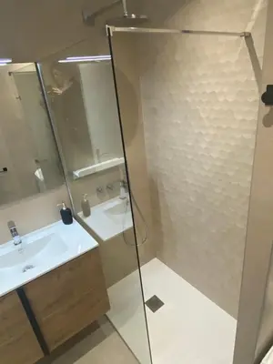 a bathroom with a glass shower and a sink at Luxury studio in Cannes