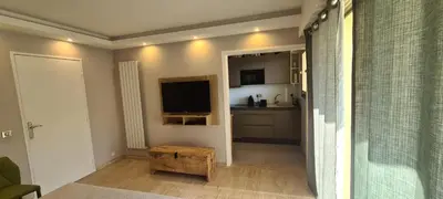 a living room with a television and a kitchen at Luxury studio in Cannes