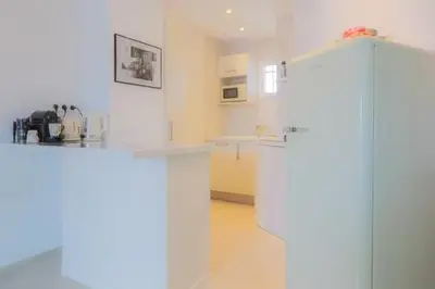 a white kitchen with a counter and a refrigerator at LOFT CROISETTE VUE Mer in Cannes