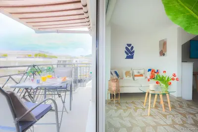 a room with a balcony with a table and chairs at LOFT CROISETTE VUE Mer in Cannes