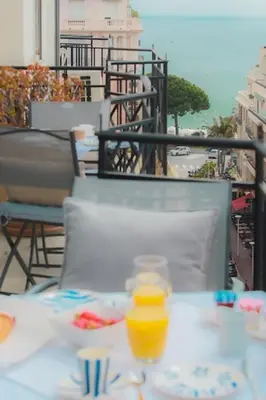 a table with a bottle of orange juice on a balcony at LOFT CROISETTE VUE Mer in Cannes