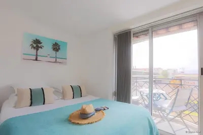 a hat on a bed in a room with a balcony at LOFT CROISETTE VUE Mer in Cannes