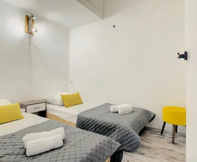 a room with two beds and a yellow chair at 2 Bedroom luxury flat Cannes Center La Croisette in Cannes