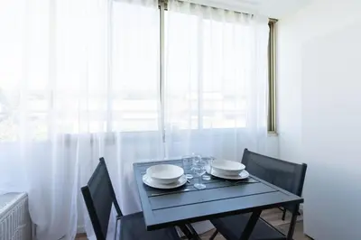 a dining room table with chairs and a window at Appartement bord de mer in Cannes