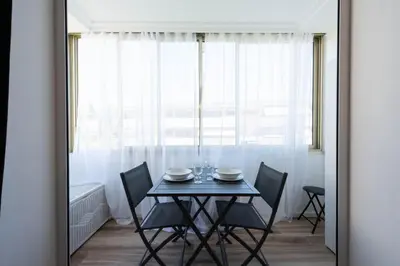 a dining room with a table and chairs and a window at Appartement bord de mer in Cannes