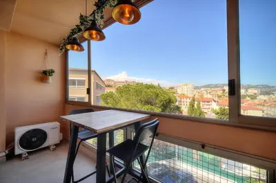 a table and two chairs in a room with a large window at IMMOGROOM - Renovated - Loggia - Clear view - Parking common - AC - Wifi in Cannes