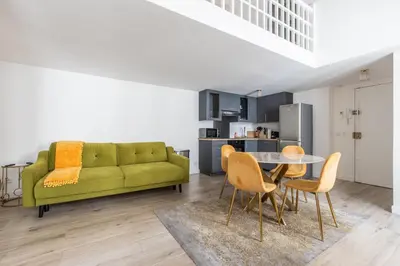 a living room with a green couch and a table at LB Vacation Rentals I Duplex Commandant Andre 65m2 I Casa d'Azur in Cannes