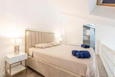 a white bedroom with a large bed and a mirror at LB Vacation Rentals I Duplex Commandant Andre 65m2 I Casa d'Azur in Cannes
