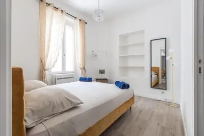 a white bedroom with a bed and a mirror at LB Vacation Rentals I Duplex Commandant Andre 65m2 I Casa d'Azur in Cannes