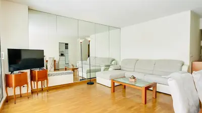 a living room with a white couch and a tv at Cannes : superbe terrasse rue d'Antibes in Cannes