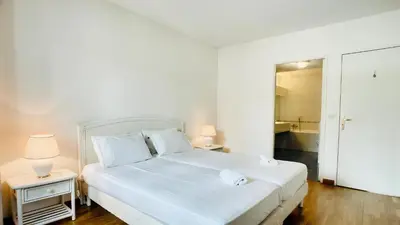 a bedroom with a white bed with two night stands at Cannes : superbe terrasse rue d'Antibes in Cannes