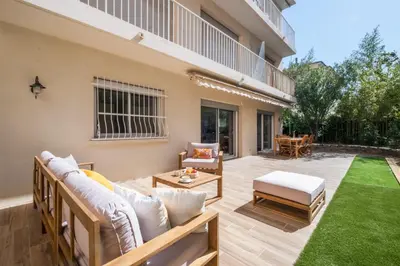 a patio with a couch and a table at 2-Bedroom Apartment with Garden in Cannes