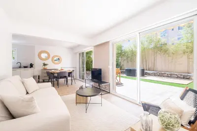a living room with a white couch and a large window at 2-Bedroom Apartment with Garden in Cannes