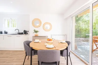 a kitchen and dining room with a wooden table and chairs at 2-Bedroom Apartment with Garden in Cannes