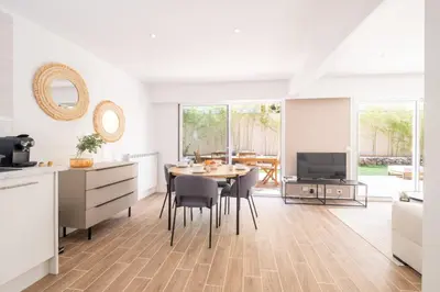 a kitchen and dining room with a table and chairs at 2-Bedroom Apartment with Garden in Cannes