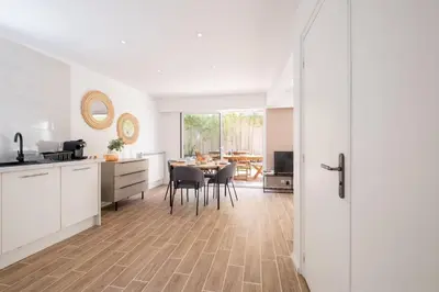a kitchen and dining room with a table and chairs at 2-Bedroom Apartment with Garden in Cannes