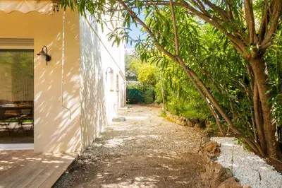 an alleyway leading to a house with trees at 2-Bedroom Apartment with Garden in Cannes