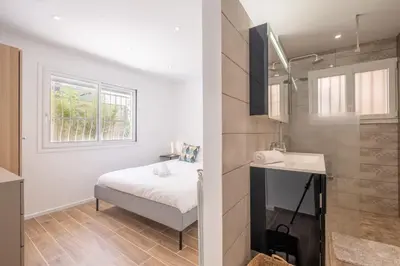 a bathroom with a bed and a sink in a room at 2-Bedroom Apartment with Garden in Cannes